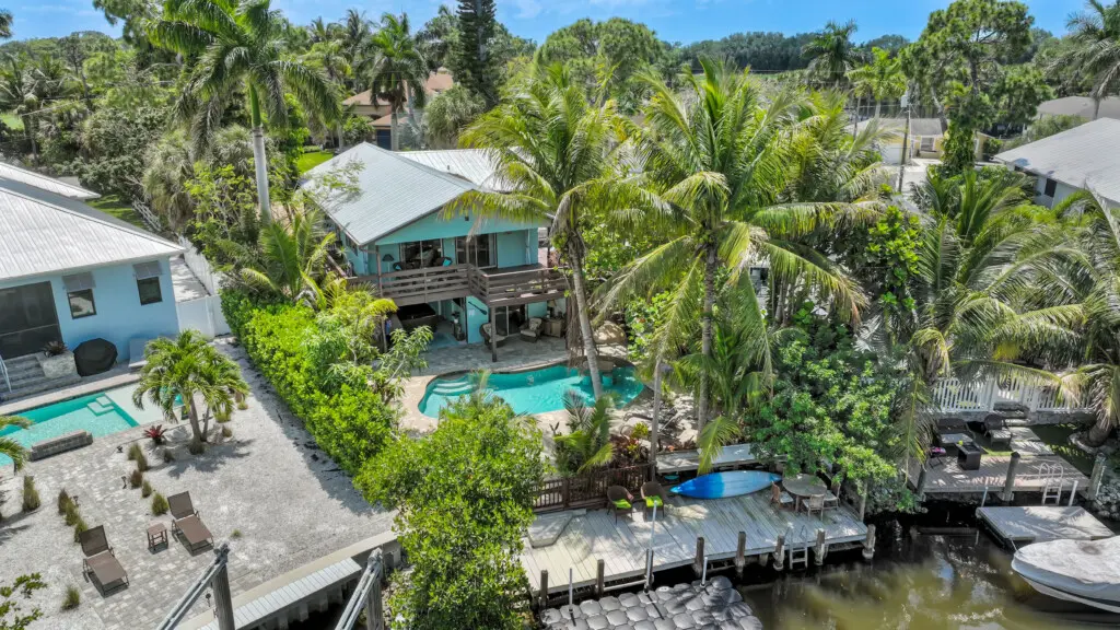 Luxury waterfront vacation rental in Naples Florida with private pool, boat dock, and tropical landscaping